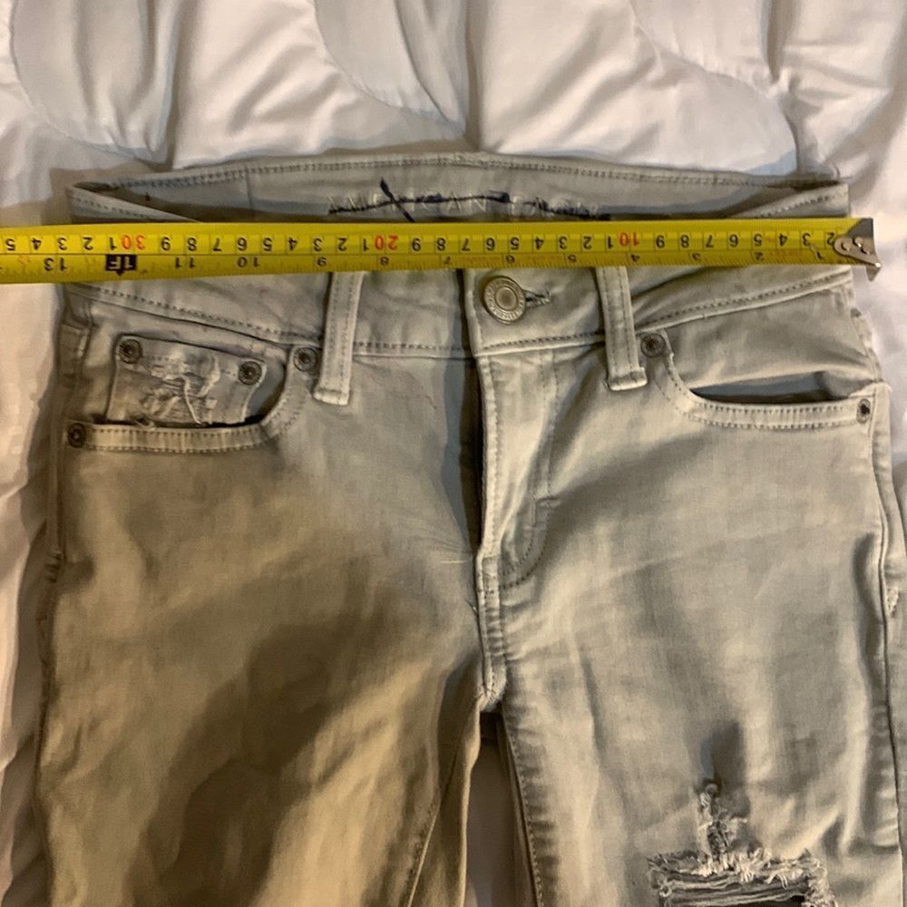American Eagle Size 00 Super Strechy off white Jeans. Lots of Holes